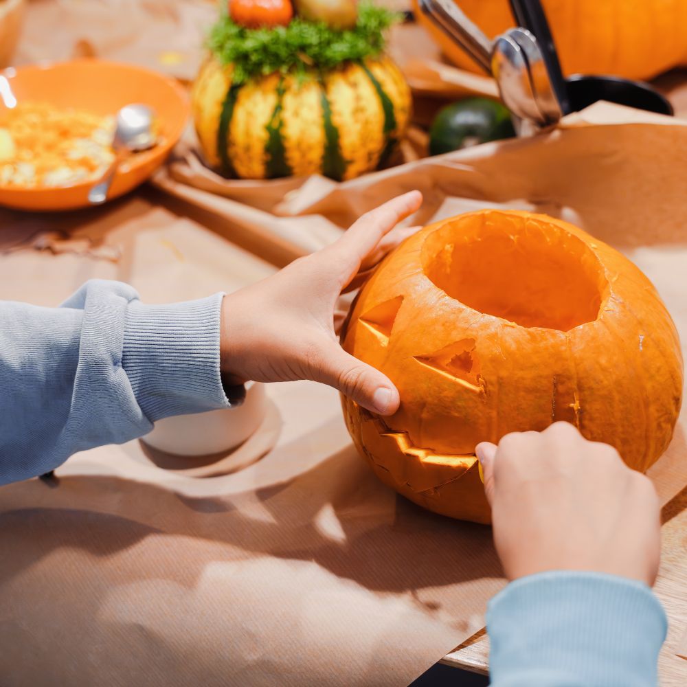 Enfant creusant une citrouille pour Halloween