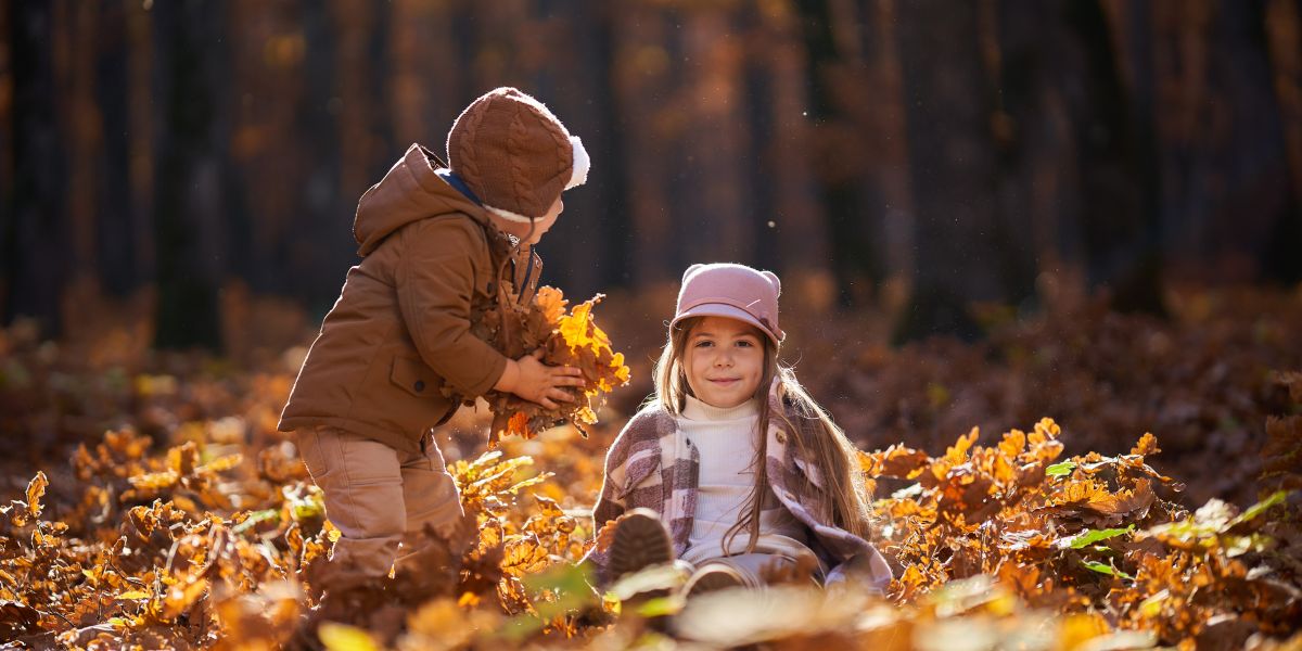Deux enfants jouant dans les feuilles mortes en automne